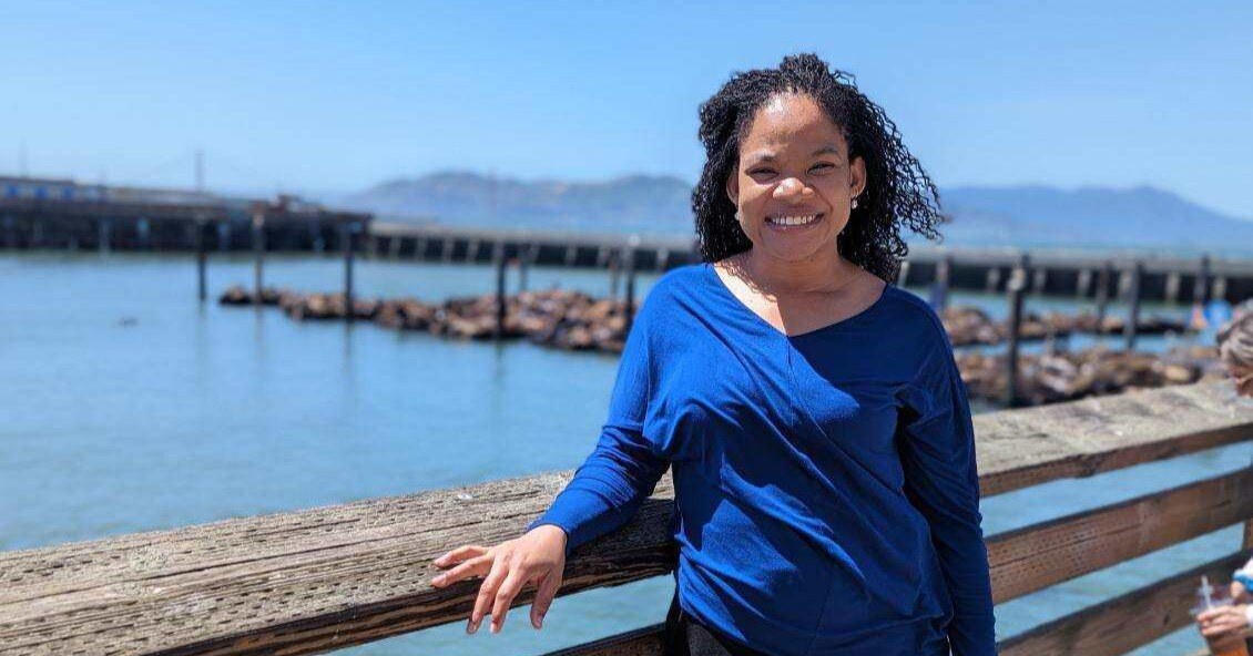 Dr. Nelson stands in front of a pier on the water