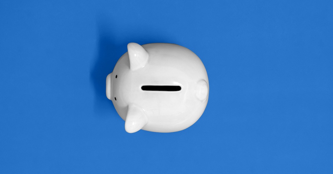 Aerial of white piggy bank on blue background