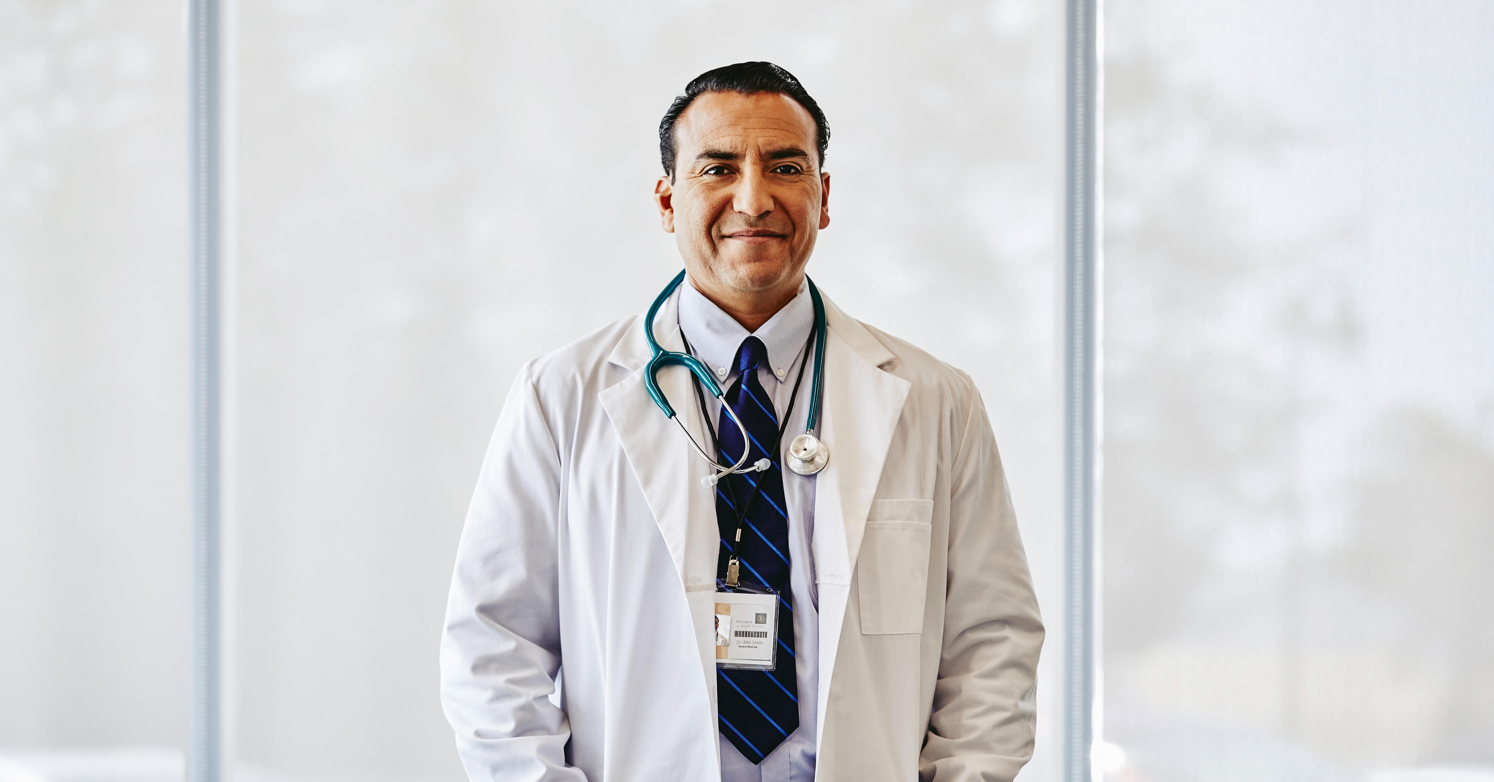 Physician looks and smiles directly at camera