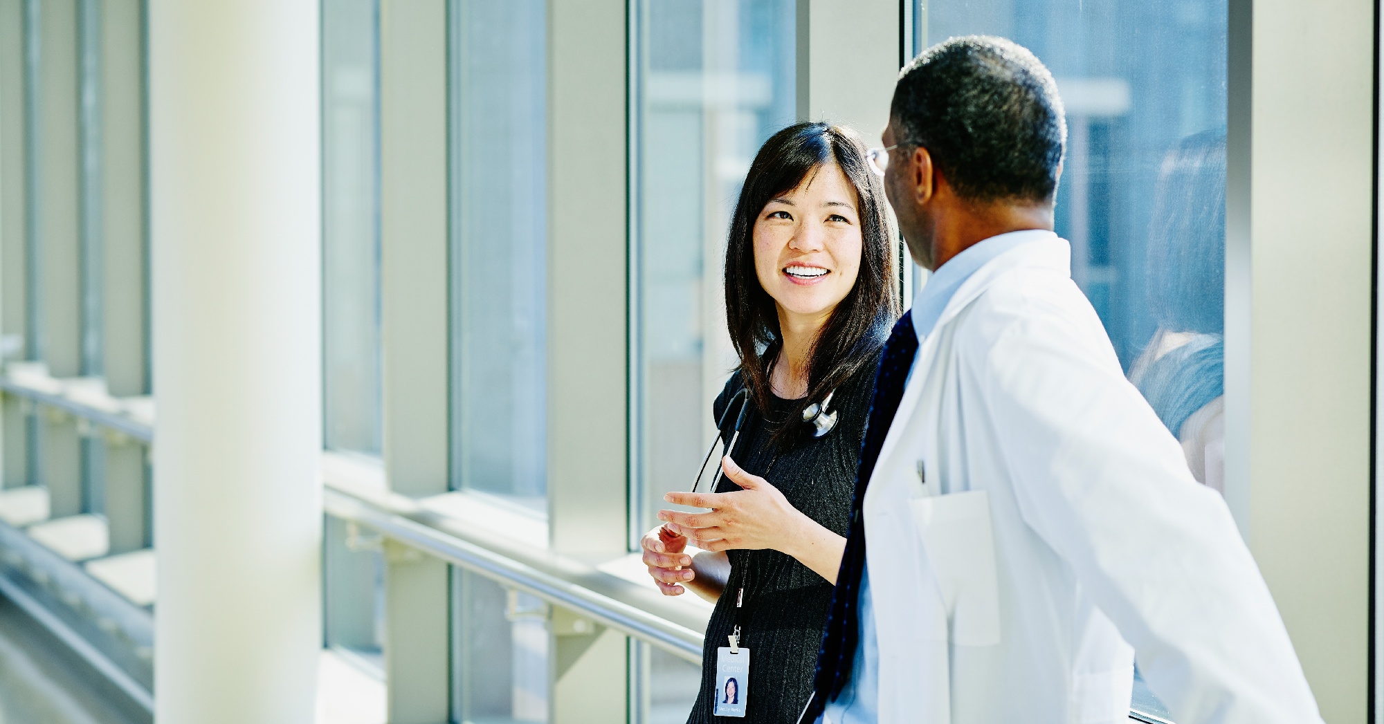 Physician liaison talks to physician in hallway